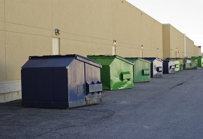 workers clearing construction waste into dumpsters in Arab AL